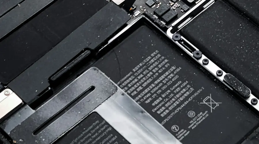 Open MacBook Pro showing its battery, cooling fan and internal components